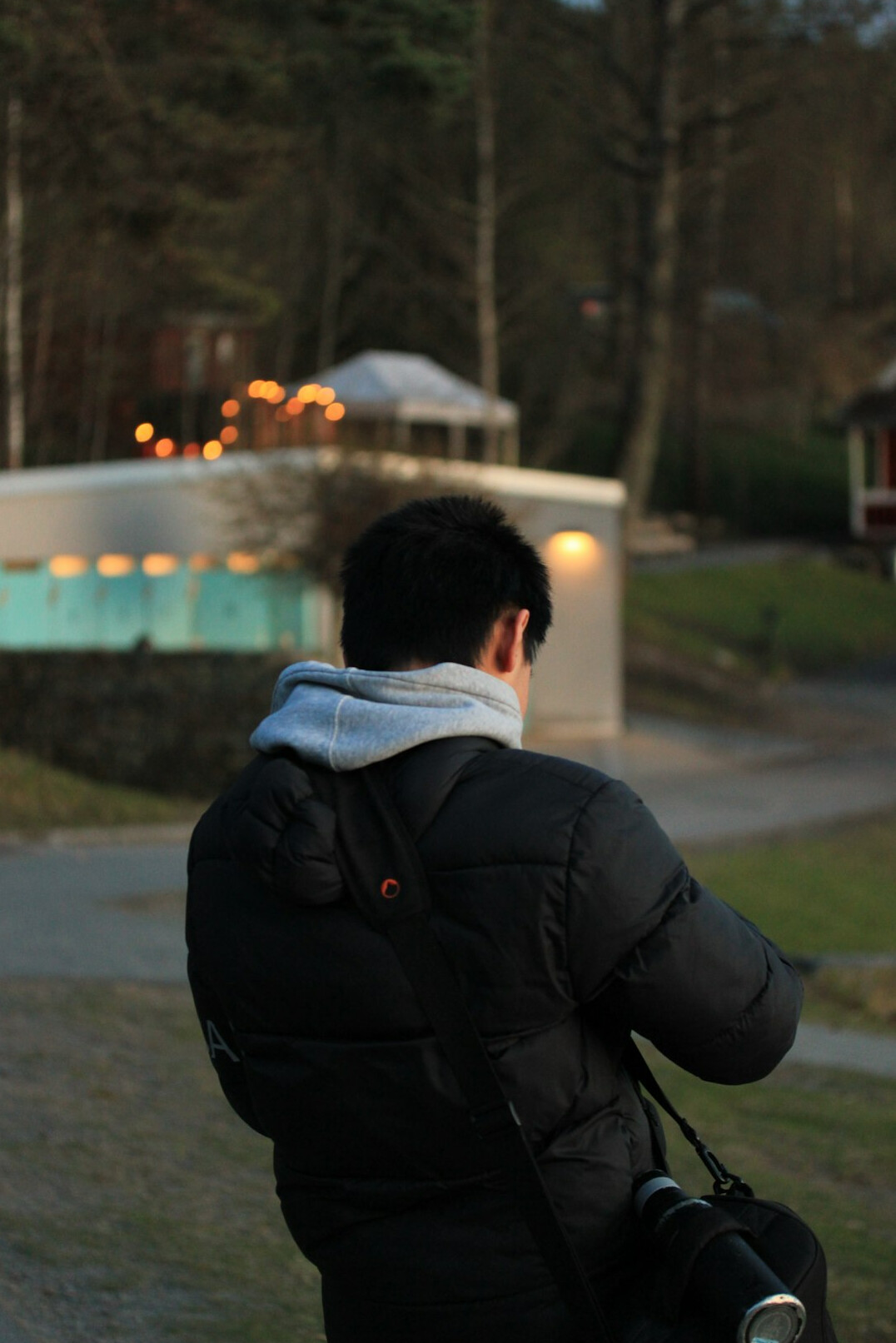 Documentary photographer holding a camera outdoors in soft light